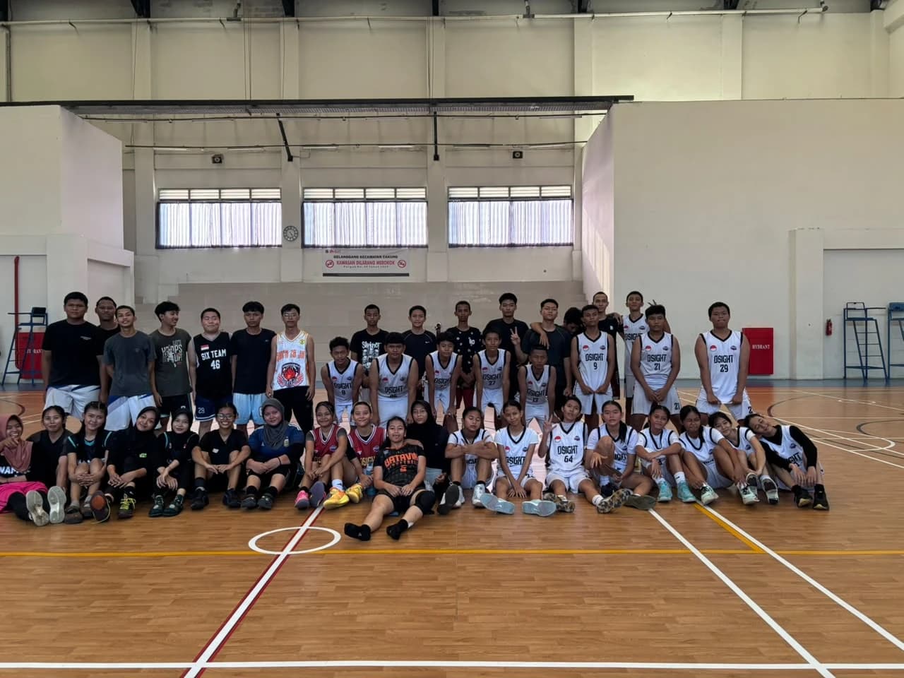 Foto bersama anggota Basket putra dan putri SMKN 69 Jakarta di lapangan olahraga dalam ruangan